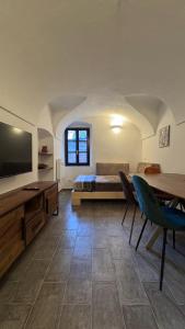 a room with a bed and a table and a television at Residence by Talking Stones in Dolceacqua