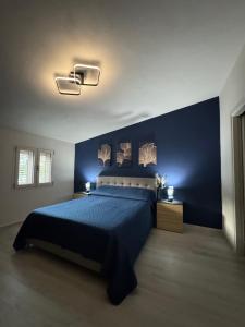 a bedroom with a bed with a blue wall at Aura Maris in Guspini