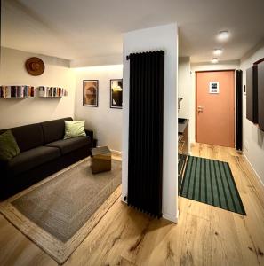 a living room with a couch and a door at Mont-Blanc Design Studio in Morgex