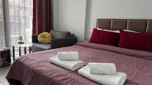 a bedroom with a bed with towels on it at Bella Luxury Suite II in Paralia Katerinis