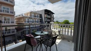 a balcony with a table and chairs on a balcony at Bella Luxury Suite II in Paralia Katerinis