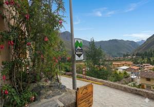 a sign on the side of a road with flowers at Coco's vibes in Ollantaytambo