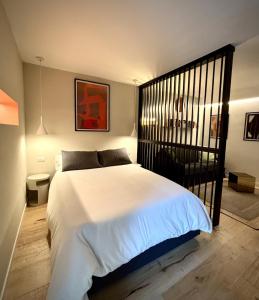 a bedroom with a large white bed with a black gate at Mont-Blanc Design Studio in Morgex