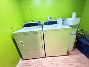 a small green room with a washer and dryer at Hotel Pacific Garden in Gardena