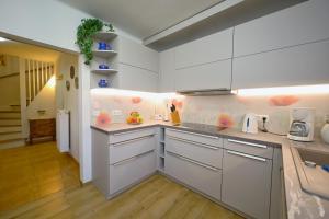 a kitchen with white cabinets and wooden floors at Ferienhaus Weitblick in Dresden