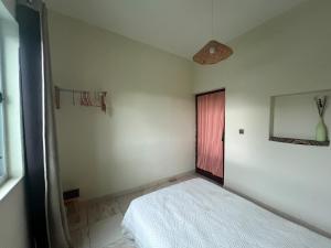 a bedroom with a white bed and a red door at Casa Tota in Assomada