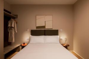 a bedroom with a white bed and a mirror at RELSTAY - Vercelli Suites in Milan