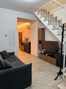 a living room with a couch and a staircase at Aura Maris in Guspini
