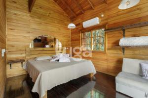 a bedroom with a bed in a room with wooden walls at Suite Low – Cyclists' Paradise in Gramado +11 photos