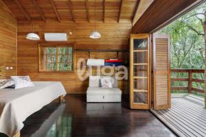 a bedroom with a bed and a chair at Suite Low – Cyclists' Paradise in Gramado