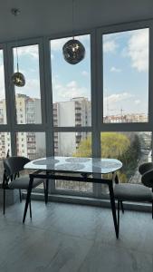 a glass table in a room with a large window at Перлина Люкс in Khmelnytskyi