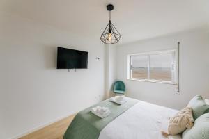 a white bedroom with a bed and a window at BESTVILLAS Âncora Rio in Vila Praia de Âncora