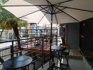 a patio with tables and an umbrella on a balcony at Hotel Pousadas Club Centro in Sorocaba