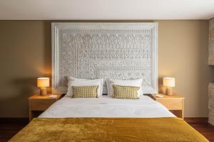 a bedroom with a large white bed with two lamps at Recanto de Passos - Amarante in Amarante +93 photos