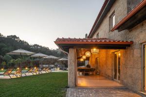 a house with a patio with chairs and a table at Recanto de Passos - Amarante in Amarante