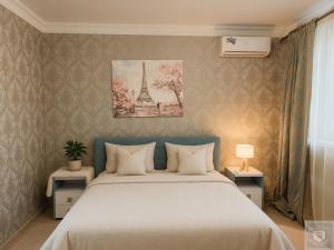 a bedroom with a bed and a picture of the eiffel tower at RentHouse Apartments Smart-Accomodation in Chişinău