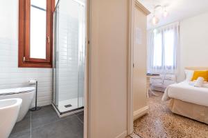 a bathroom with a shower and a bed and a sink at Rigoletto Apartments by Fenix in Venice +21 photos