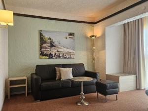 a living room with a couch and a table at CONTEL Hotel in Koblenz