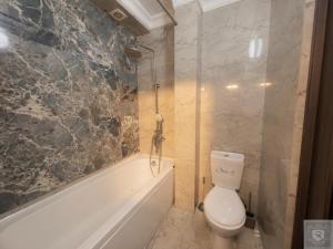 a bathroom with a white toilet and a bath tub at RentHouse Apartments Smart-Accomodation in Chişinău +9 photos