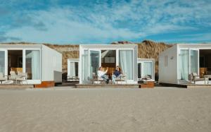 a person sitting in a chair on a beach at Lua Beach House in Zandvoort