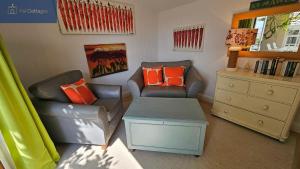 a living room with two chairs and a table at The Summer House in Saint Mawes