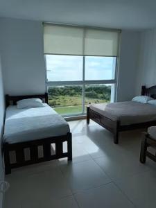 a bedroom with two beds and a large window at Playa Blanca Ocean ll in Playa Blanca +36 photos