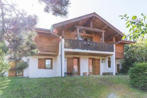 a house with a balcony on top of it at Chalet Au Gré Du Temps in Les Gets