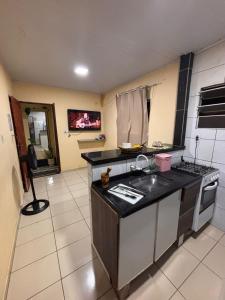 a kitchen with a sink and a counter top at Casa de temporada 08 Pessoas PISCINA LAZER Entretenimento pra família in João Pessoa
