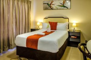 a hotel room with a large bed with two lamps at Hillview inn hotel in Serowe