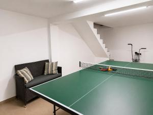 a ping pong table in a room with a couch at Casa Liniștea Pădurii in Gura Văii
