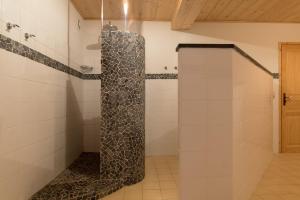 a shower in a bathroom with white tiles at Chalet Au Gré Du Temps in Les Gets +13 photos