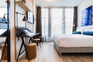 a hotel room with a bed and a desk at Le Grand Quartier in Paris +73 photos