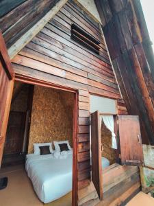 a bedroom with two beds in a wooden house at เคียงสะปันโฮม&คาเฟ่ in Ban Huai Ti