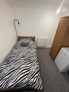 a bedroom with a zebra print bed in a room at Serenity LTD in Leicester