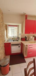 a kitchen with red cabinets and a sink at La Maison du Cros in Cassagnes-Bégonhès +28 photos