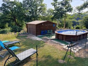 a small building and a pool in a yard at La Maison du Cros in Cassagnes-Bégonhès