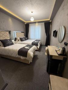 a hotel room with two beds and a table at Divan Tower Otel in Erzurum