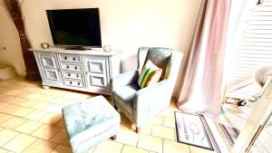 ein Wohnzimmer mit einem Sessel und einem Fernseher in der Unterkunft Ella2 in Grömitz