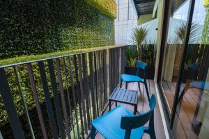 a balcony with blue chairs and a fence at Ambulan Mexico City in Mexico City