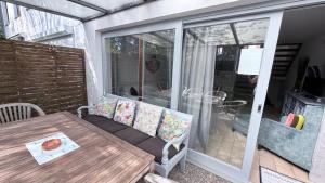 eine überdachte Terrasse mit Tisch und Glastür in der Unterkunft Ella2 in Grömitz
