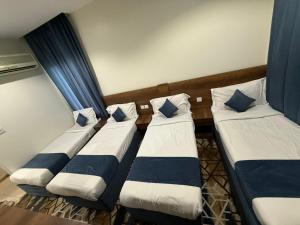a group of four beds sitting in a room at فندق العلاء 5 in Ajyad