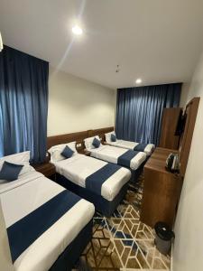 a group of four beds in a room at فندق العلاء 5 in Ajyad