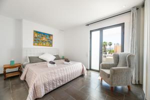 a bedroom with a bed and a chair at Can Olivera in Nuestra Señora de Jesus +21 photos