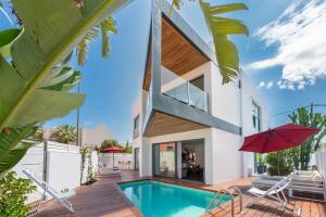 a house with a swimming pool and a red umbrella at Can Olivera in Nuestra Señora de Jesus