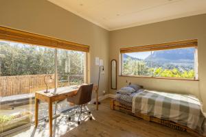 a bedroom with a desk and a bed and a window at New Mountain Retreat with Scenic Views in Hout Bay +114 photos