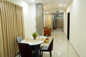 a room with a table and chairs and a hallway at Elite Residency Bhadrachalam in Bhadrāchalam