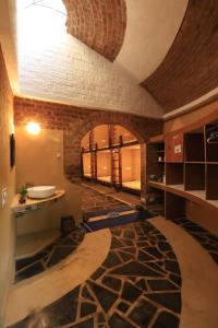 a bathroom with a sink and a stone wall at Surwahi Social Ecoestate Kanha in Kānha +64 photos
