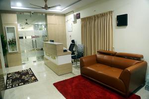 a living room with a leather couch and a desk at Elite Residency Bhadrachalam in Bhadrāchalam