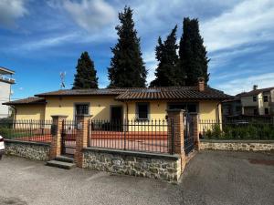 a yellow house with a black fence at Antico Granaio di LEO Via Antonia 60 in Ponte Pattoli