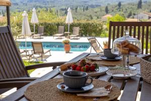 a table with food on it with a view of a pool at Marcora Historic Mansion in Strongylí +63 photos